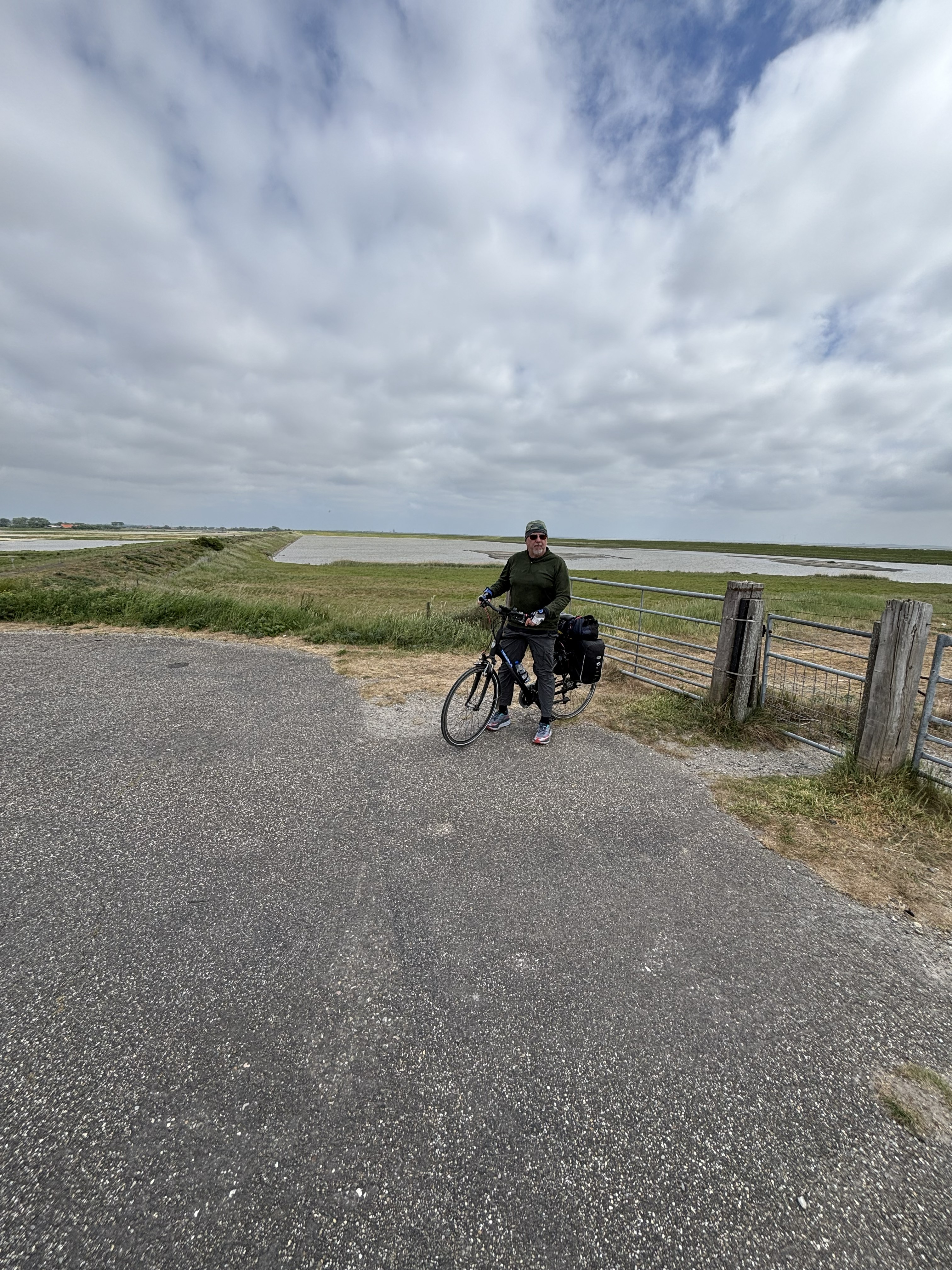 Mike on bike with coastal flats behind