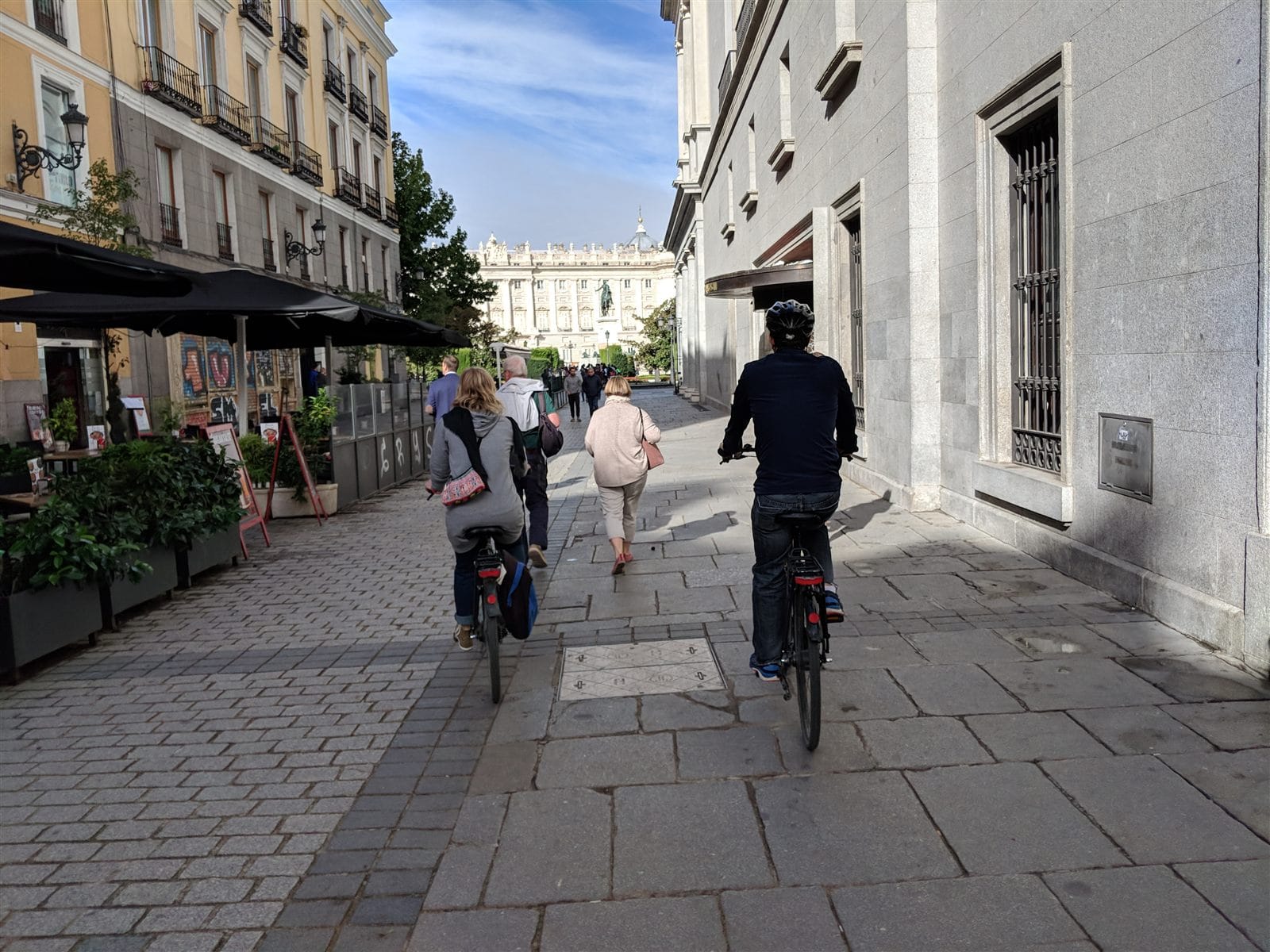 Cyclists riding toward the Royal Palace of Madrid