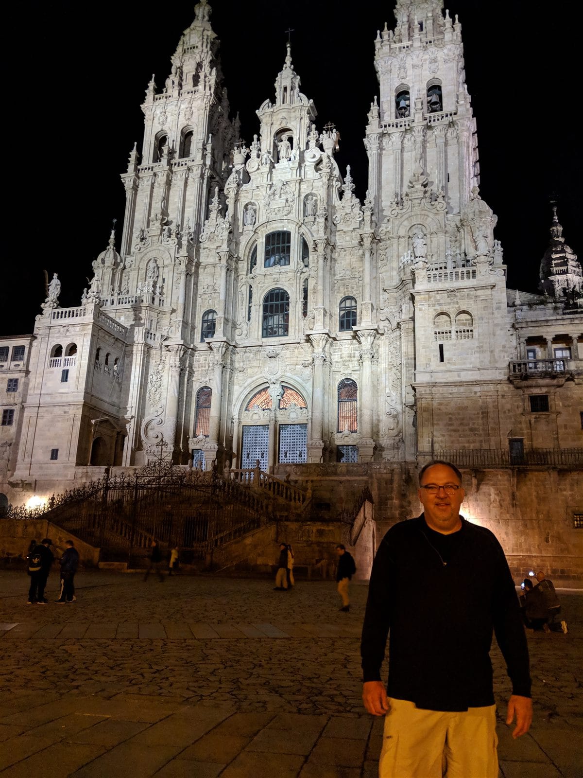 Mike in front of the floodlit Cathedral of Santiago de Compostela at night