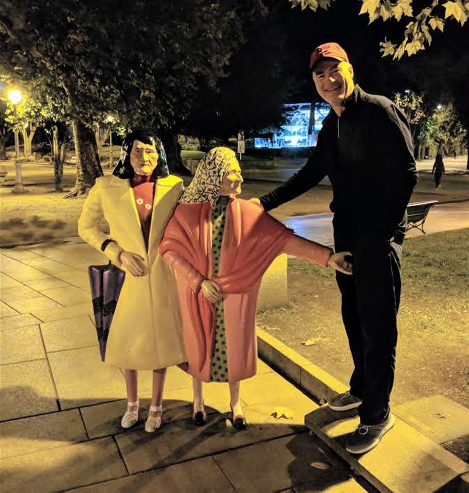 Mike with the Las Dos Marías statues in Santiago's Alameda park at night