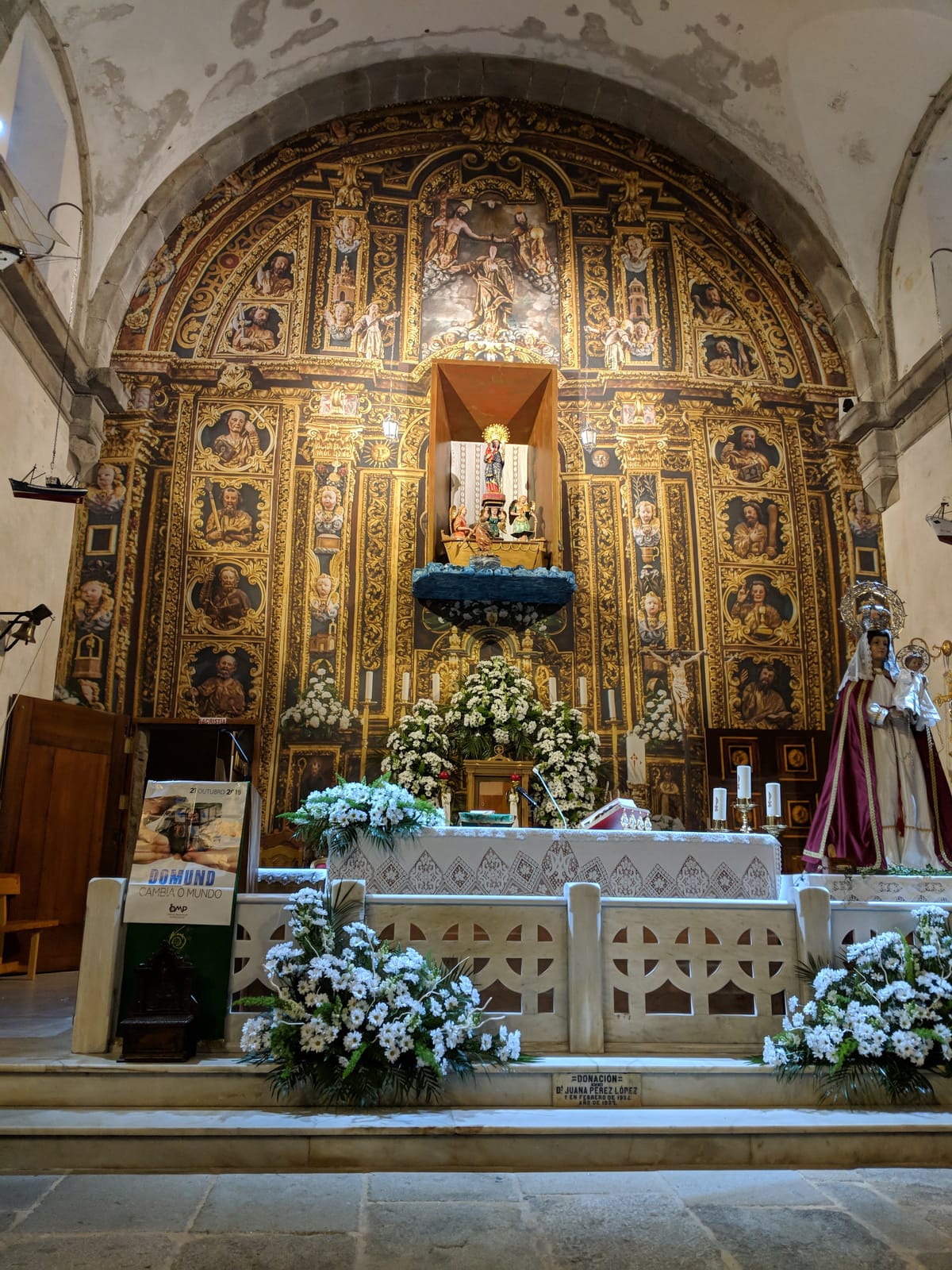 The gilded Baroque altarpiece inside the sanctuary, the Virgin set above a small stone boat