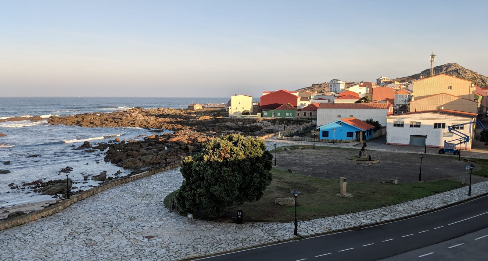 Morning view of the Muxía coast and town from our room, warm light on the water