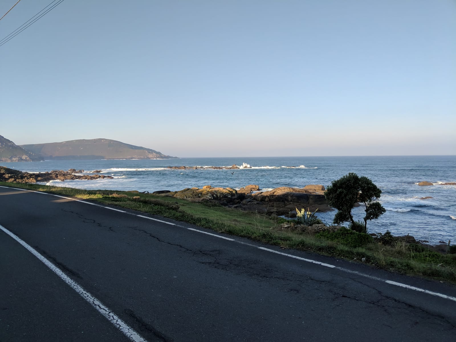 Coast road above a rocky headland with crashing waves