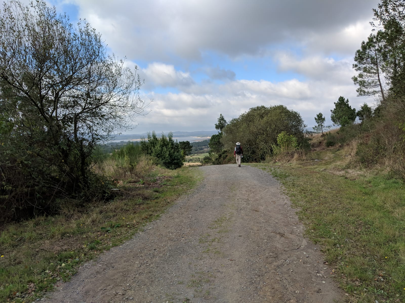 Doug on a broad gravel track with a distant view over the hills