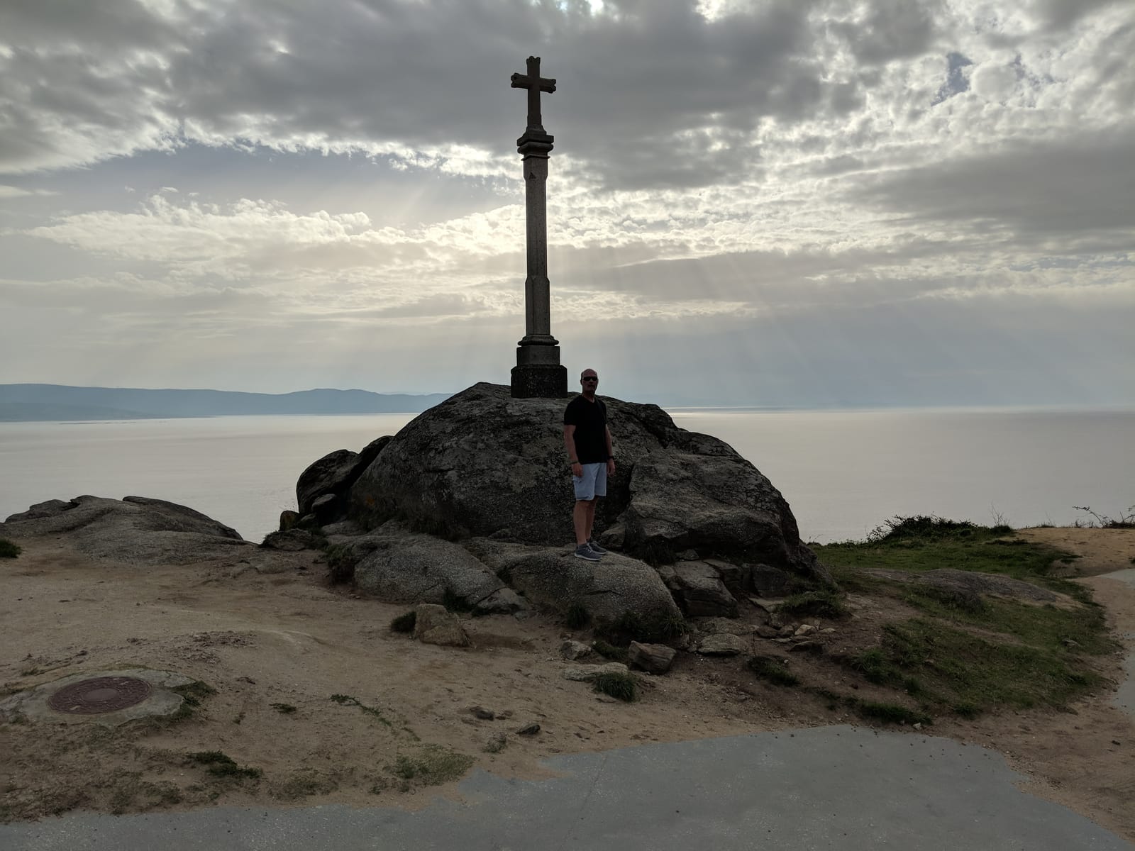 Doug standing beside the stone cruceiro at Cape Finisterre