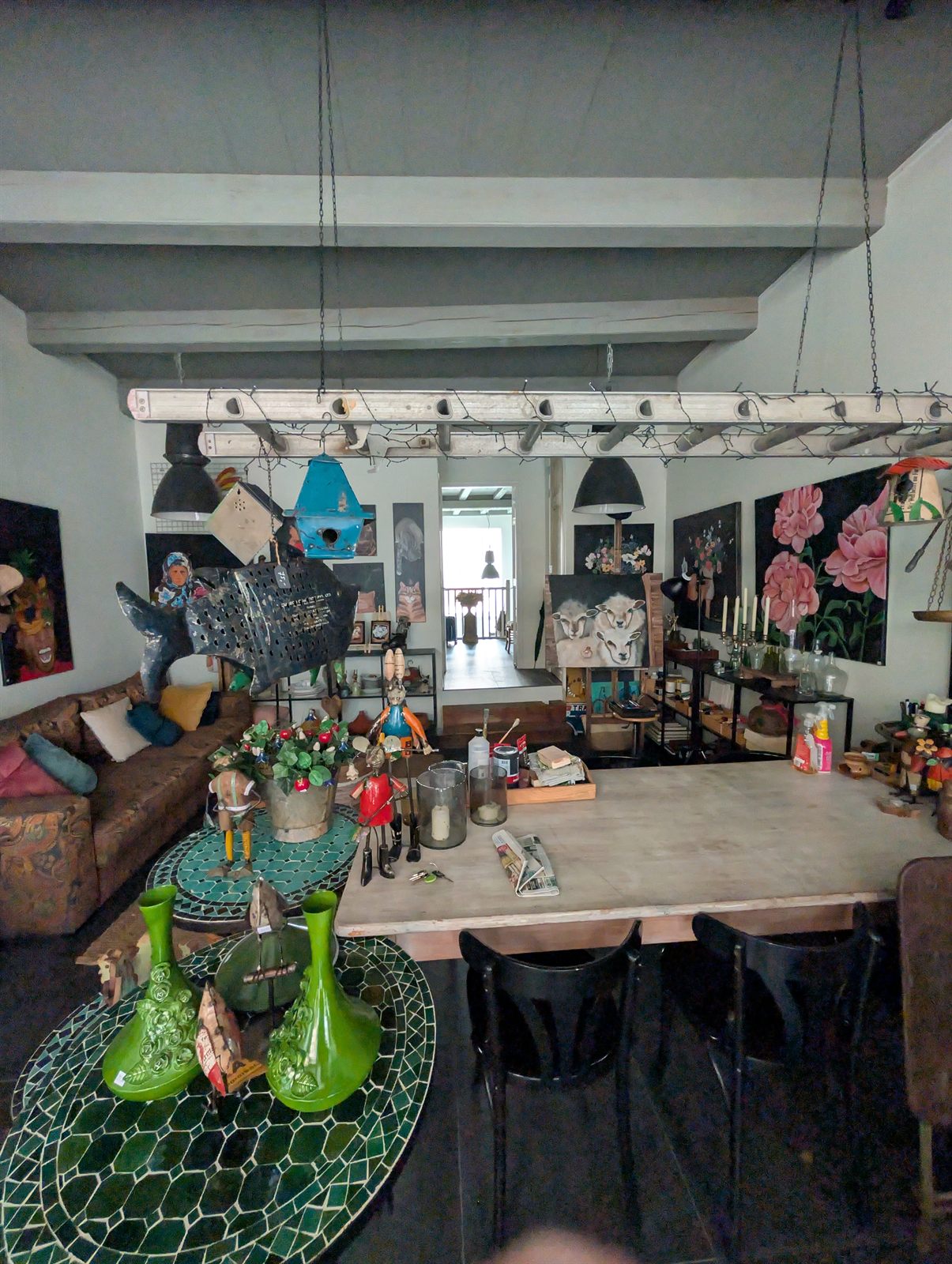 The ground floor of 267 today: heavy painted ceiling beams, a long table, paintings and objects, and a doorway leading toward the back of the house