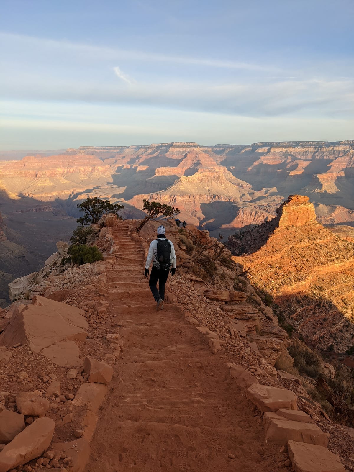 Doug hiking down the South Kaibab Trail with O'Neill Butte glowing in the morning sun