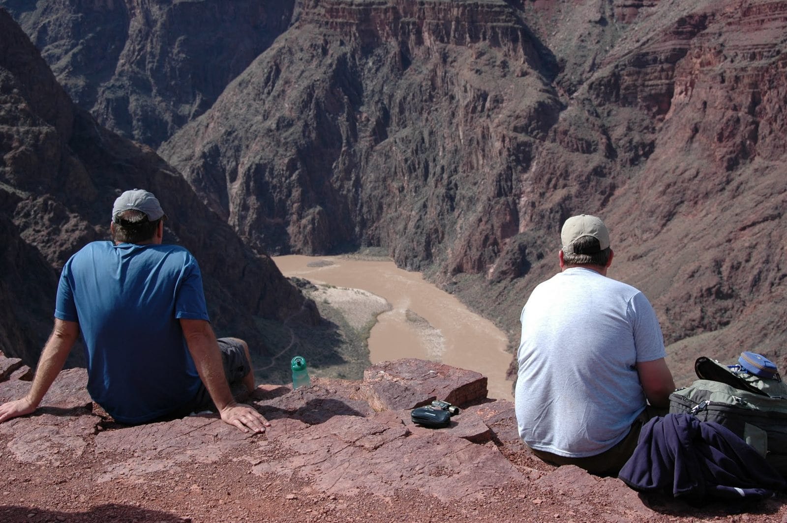 Two hikers resting at the Colorado River in the Grand Canyon