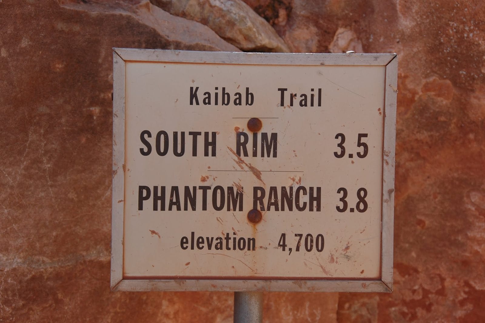 Kaibab Trail sign in the Grand Canyon: South Rim 3.5 miles, Phantom Ranch 3.8 miles, elevation 4,700