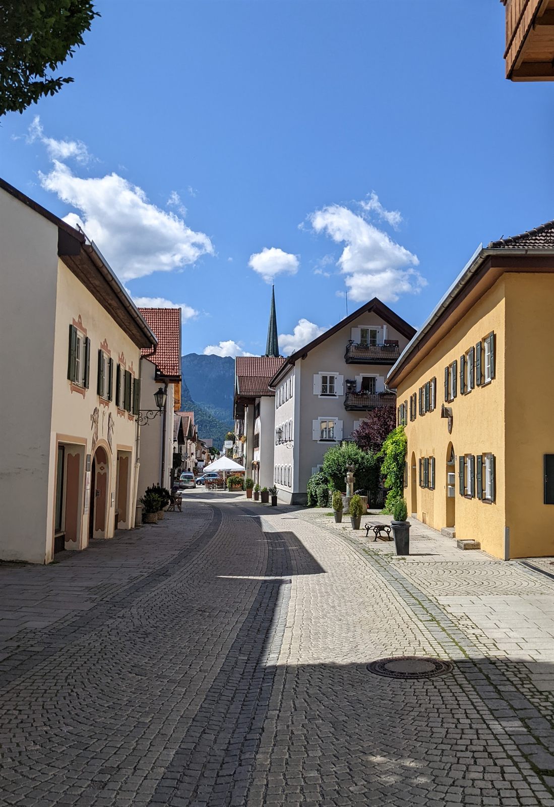 Cobblestone street in Garmisch with painted houses and mountains
