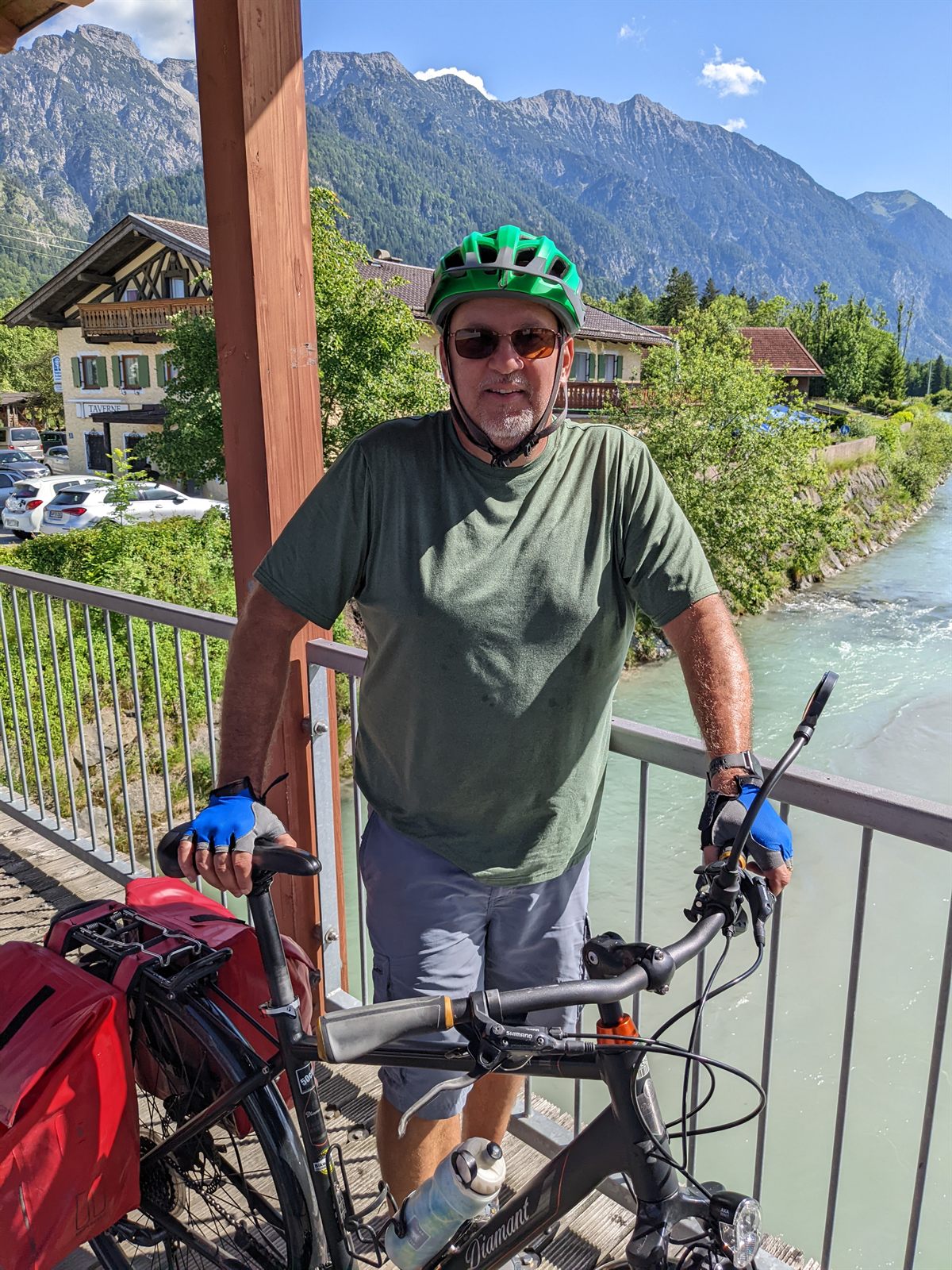 Doug with his loaded touring bike on a bridge over the Loisach, Karwendel peaks behind