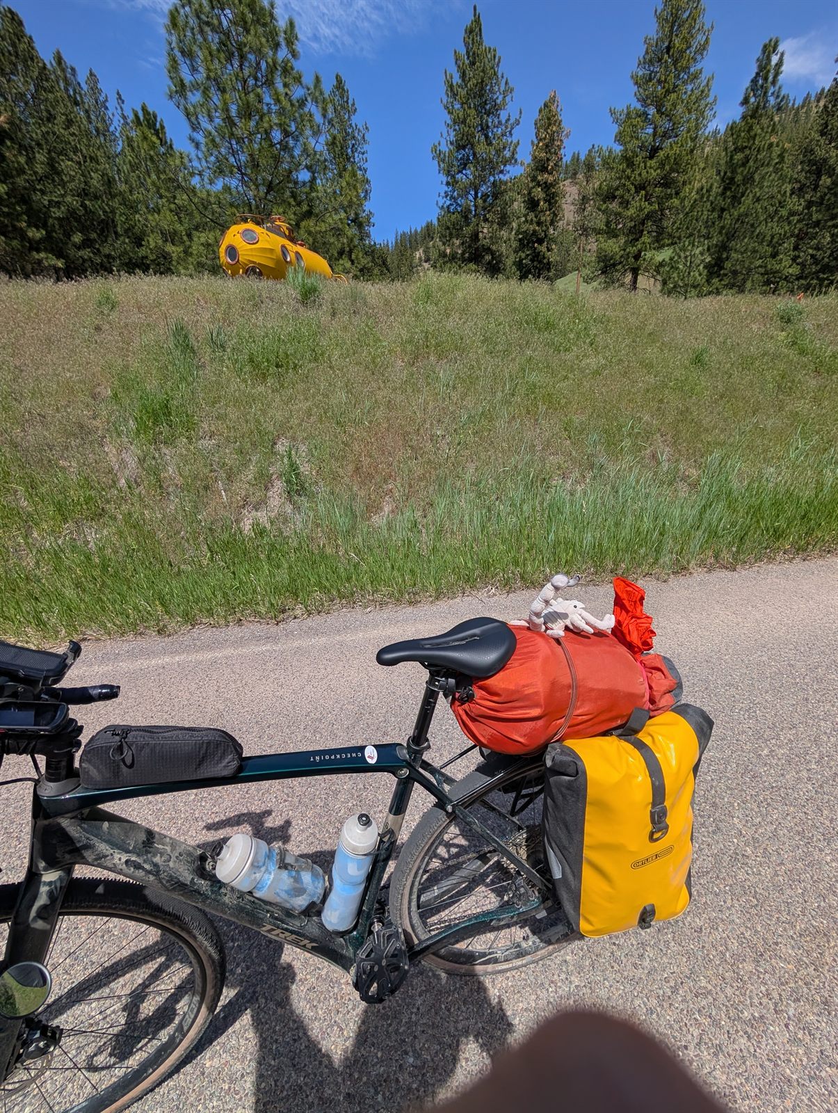 Loaded touring bike with a yellow submarine on the hillside behind it